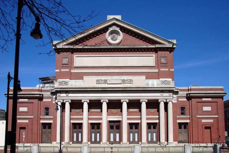 The exterior of the Boston Symphony Hall made of brick and columns in a Renaissance style