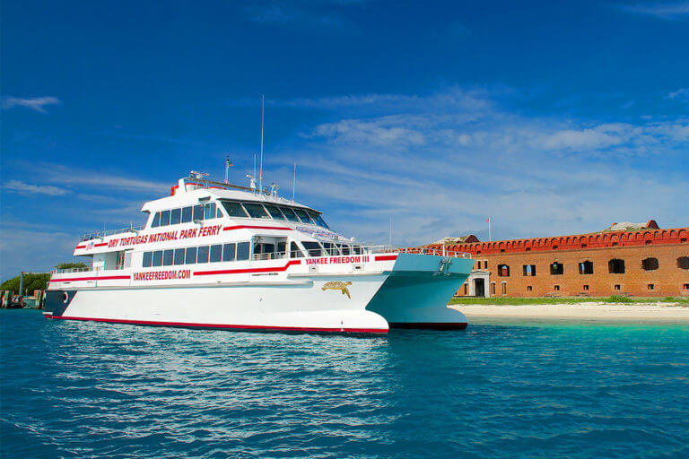 picture of a large ferry with the words 'Dry Tortugas National Park Ferry' docked in front of fort jefferson at Dry Tortugas National Park