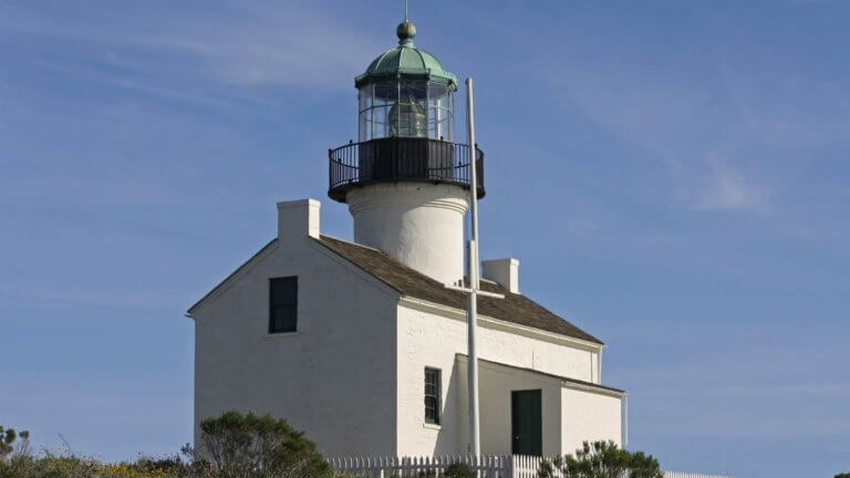 picture of a small white washed house with a lighthouse jutting out