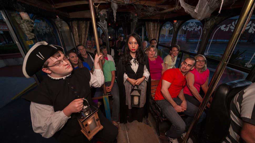 tour guides dressed in costume stare at each other on ghost tour trolley