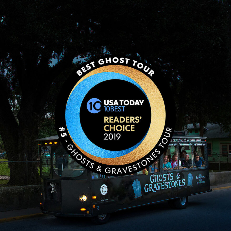 St. Augustine trolley at night driving past a cemetery and in the foreground, Round logo that reads USA Today 10 BEST READERS' CHOICE 2019' and around logo, the words 'BEST GHOST TOUR, #5 - GHOSTS & GRAVESTONES TOUR'