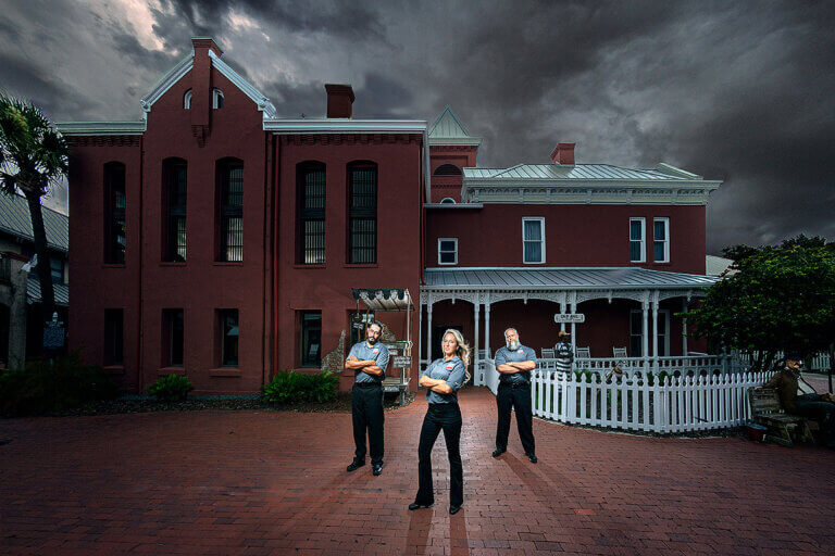 three tour guides standing in front of St. Augustine Old Jail