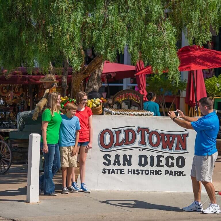 A vibrant view of Old Town San Diego, showcasing historic buildings, colorful shops, and lively street scenes under a clear sky.