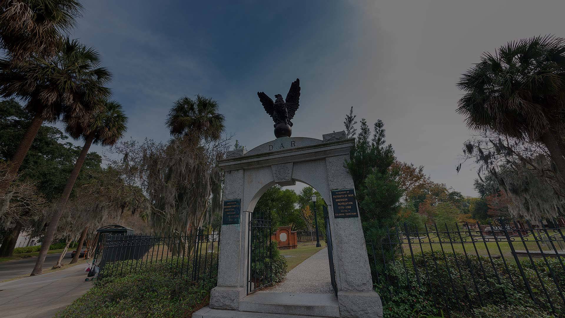 A serene view of Colonial Park Cemetery in Savannah, showcasing historic gravestones amidst lush greenery.
